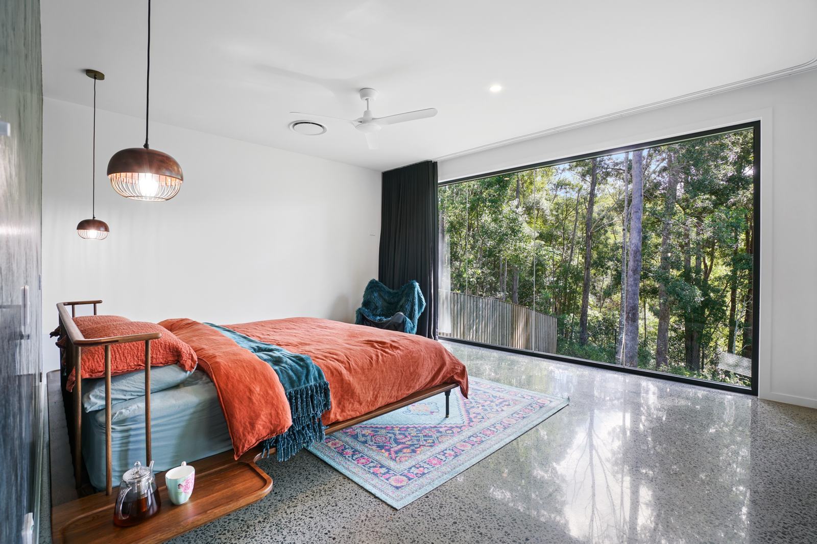Main bedroom with a floor-to-ceiling forest window