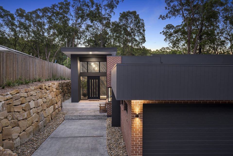 Front entry at dusk with sandstone wall