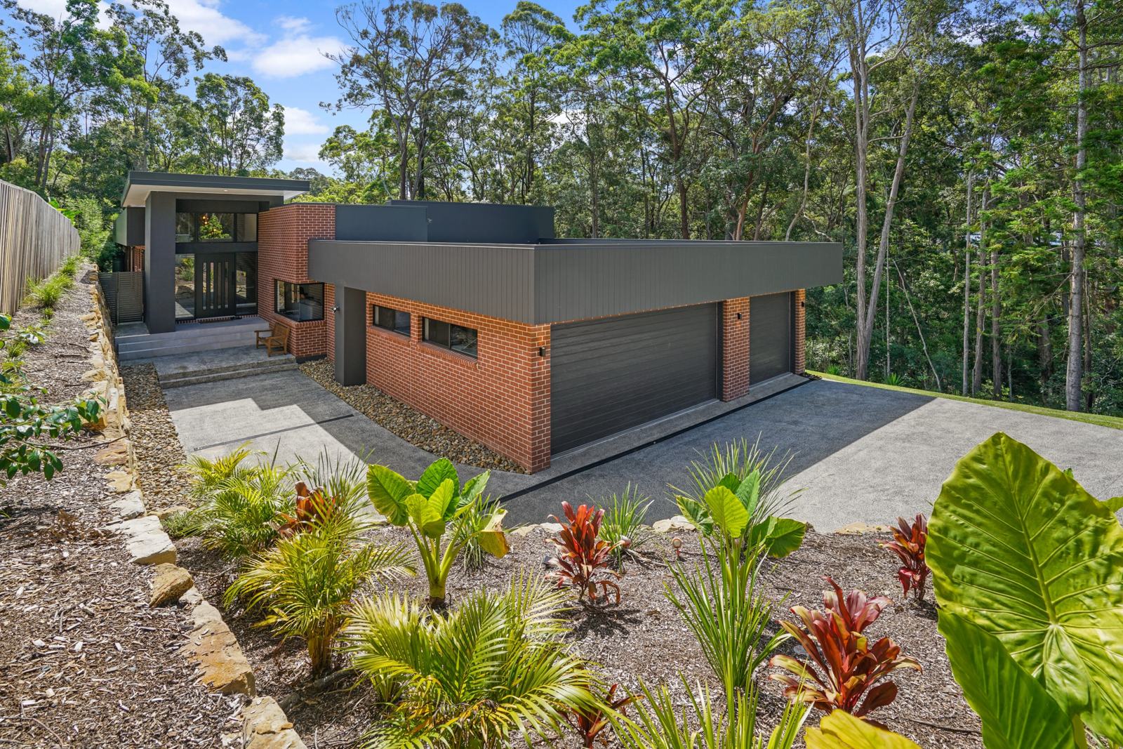 Front of the house with garage and tropical garden